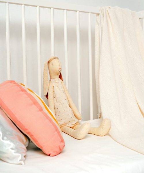 White wooden baby crib in nursery room close up